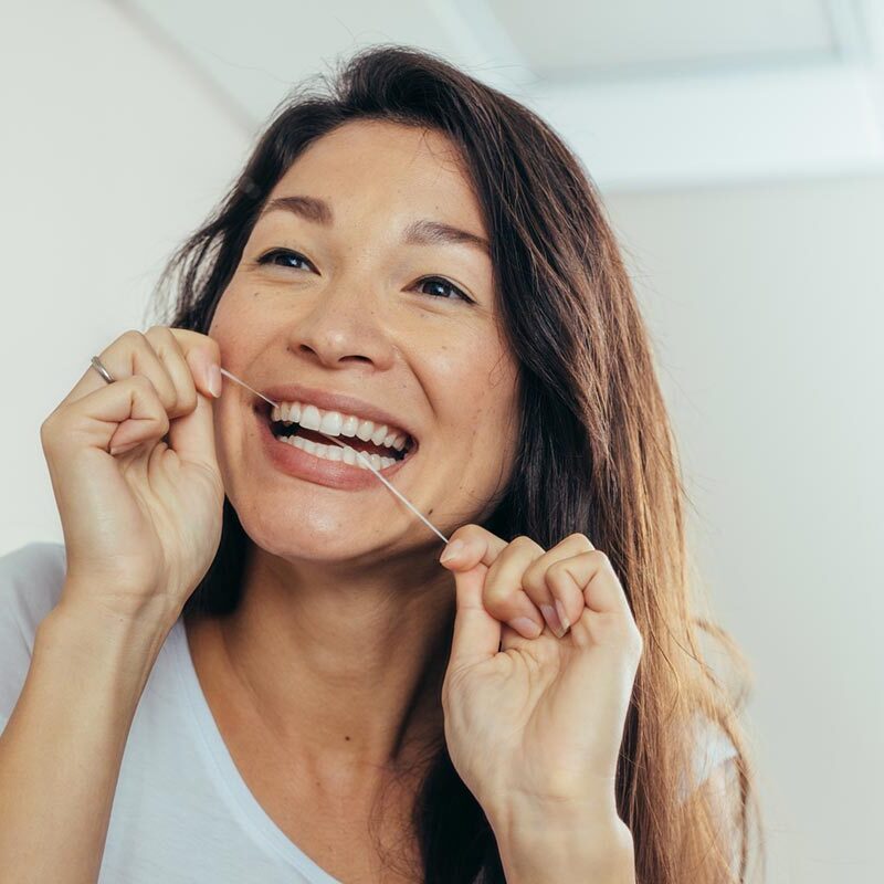 preventative dentistry woman flossing her teeth